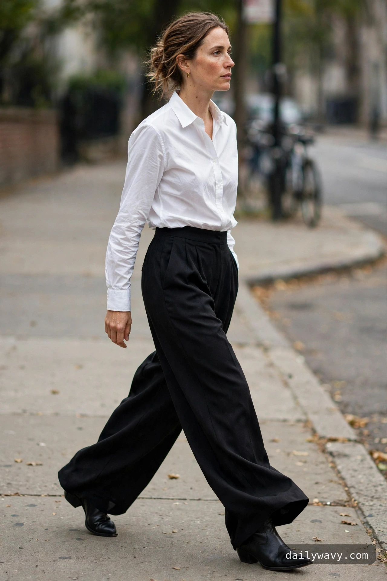 Ankle boot outfit: pointed-toe black boots under wide trousers with a tucked shirt