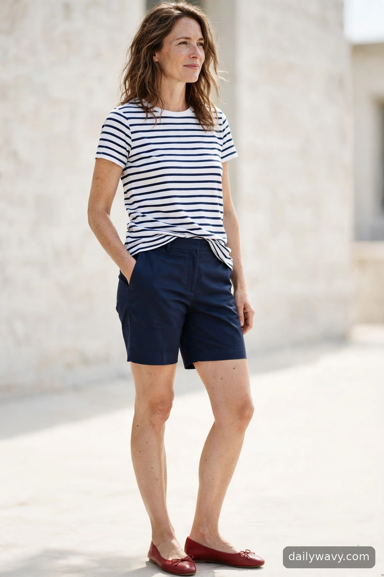 Adult wearing tailored shorts and a striped top for ballet flat outfits