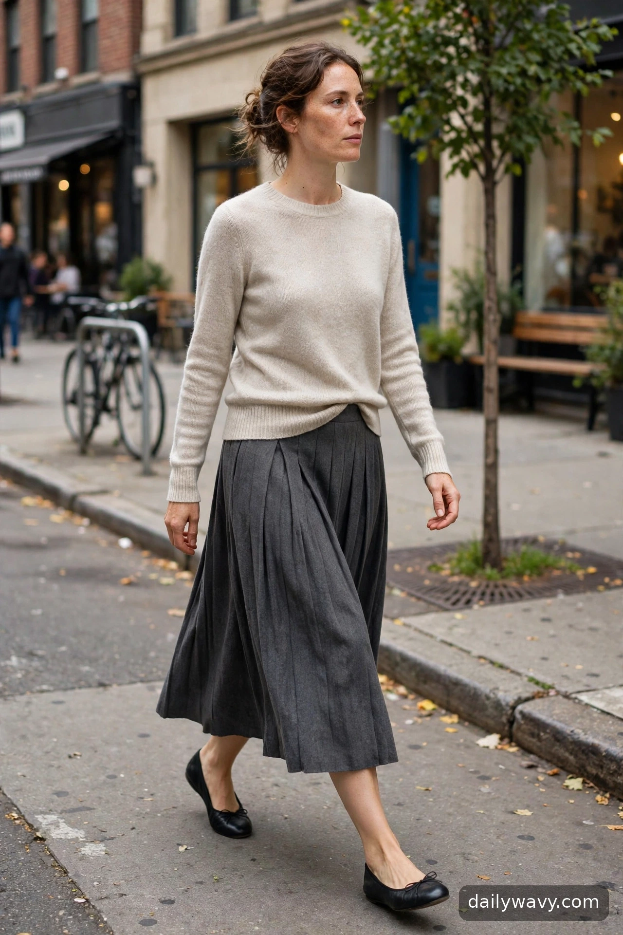 Adult wearing pleated skirt with a fine knit for ballet flat outfits