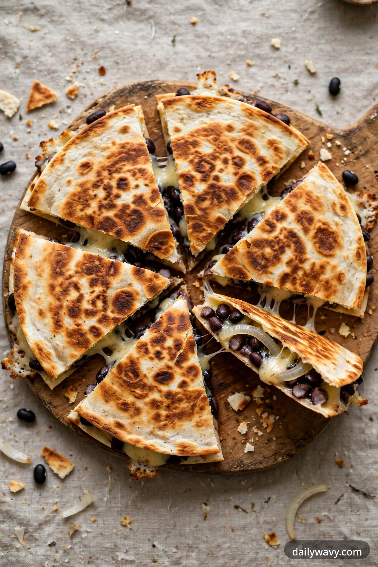 Black bean quesadilla with gouda and onion, cut into wedges on a plate