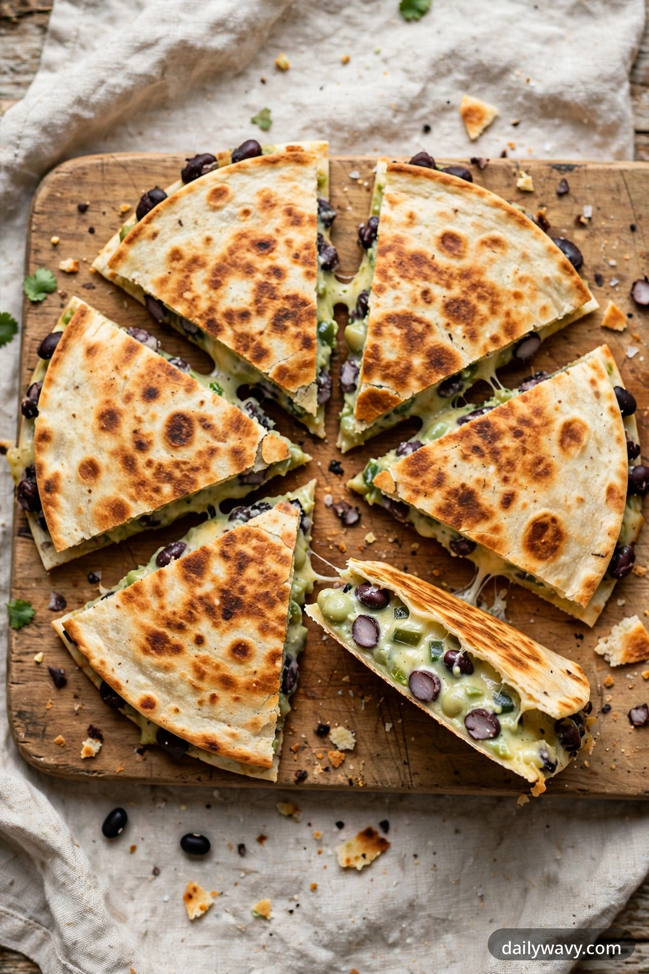 Black bean quesadilla with creamy jalapeño, cut into wedges on a plate