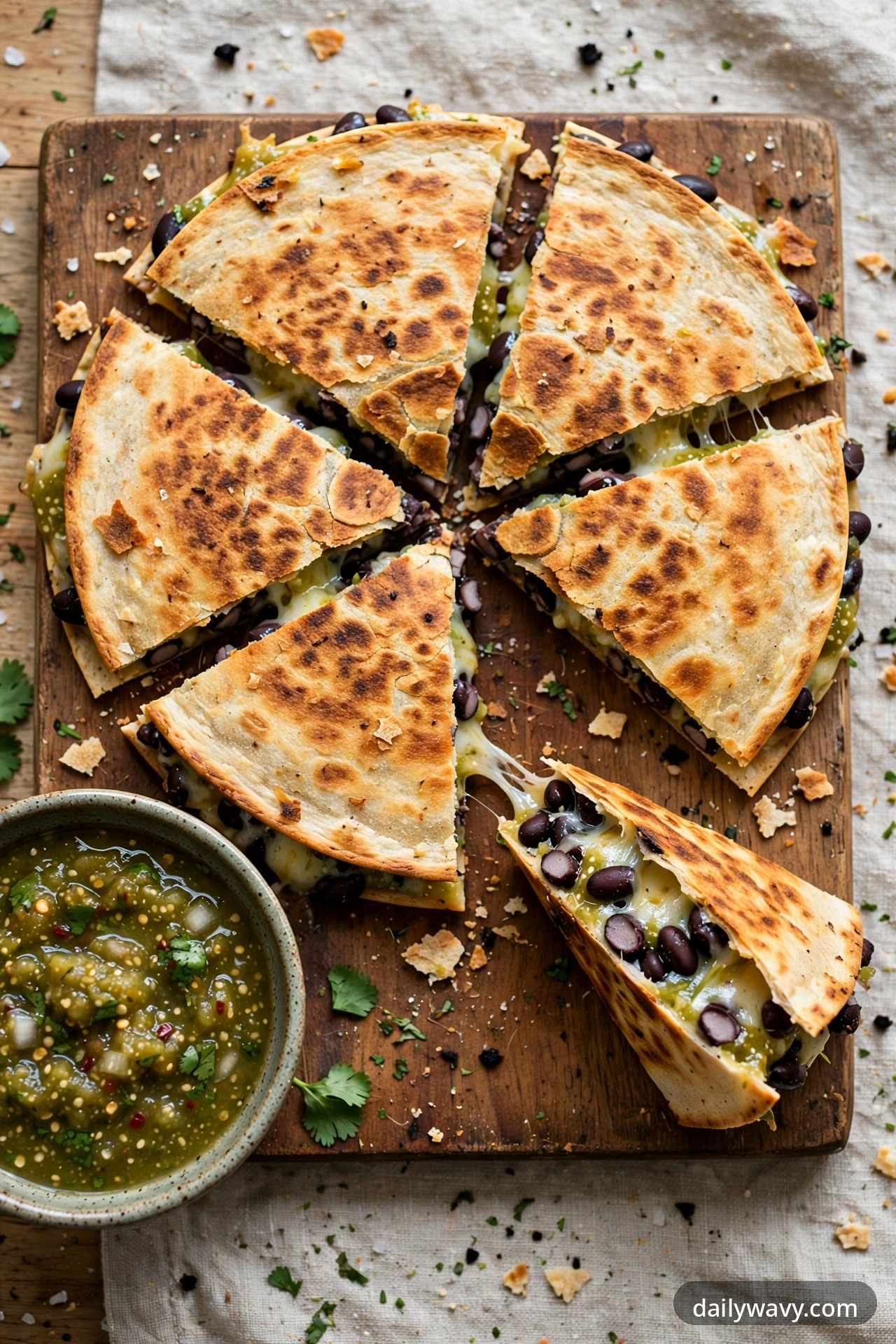 Black bean quesadilla with salsa verde, cut into wedges on a plate