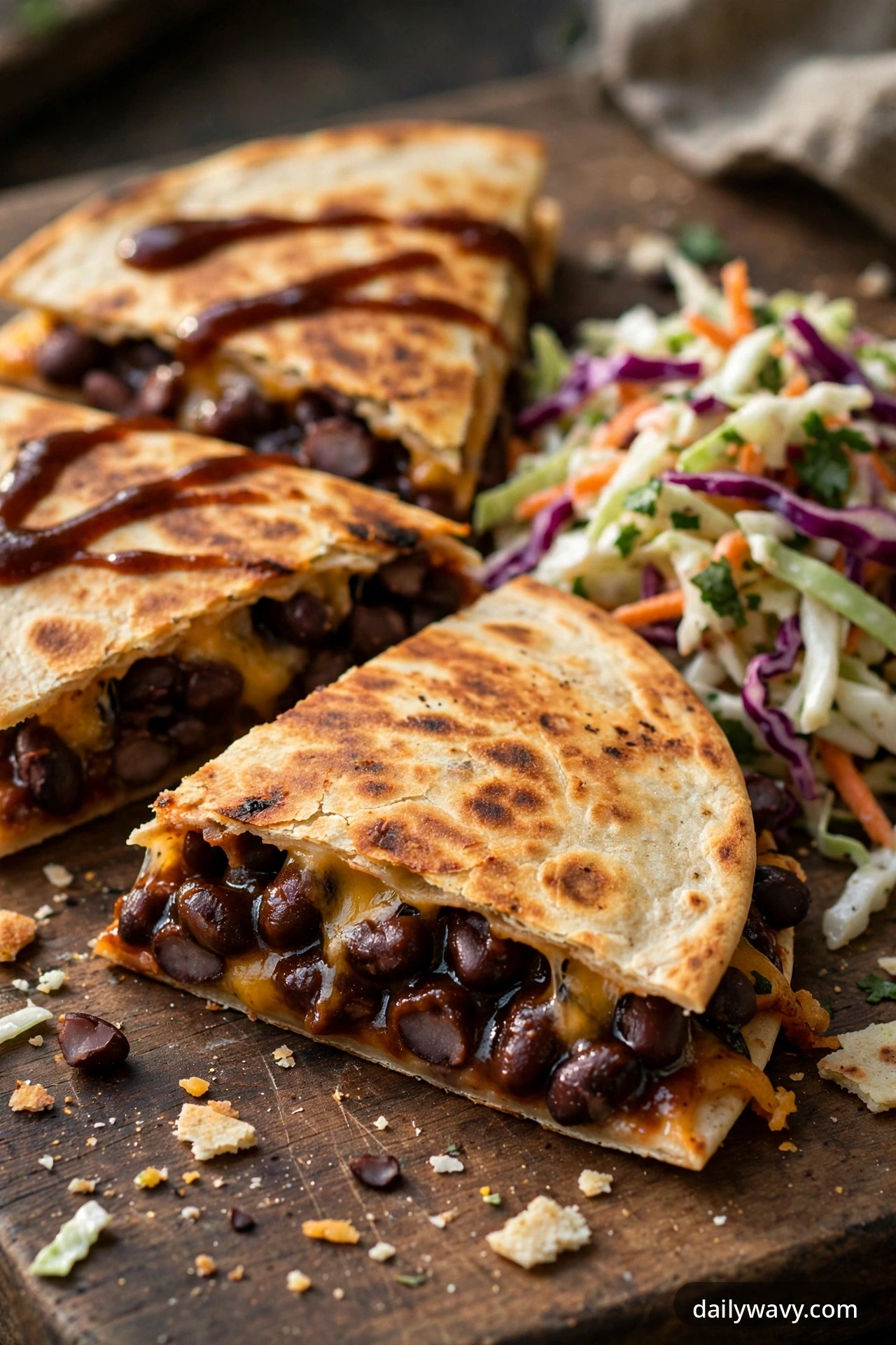 Black bean quesadilla with barbecue sauce and slaw, cut into wedges on a plate