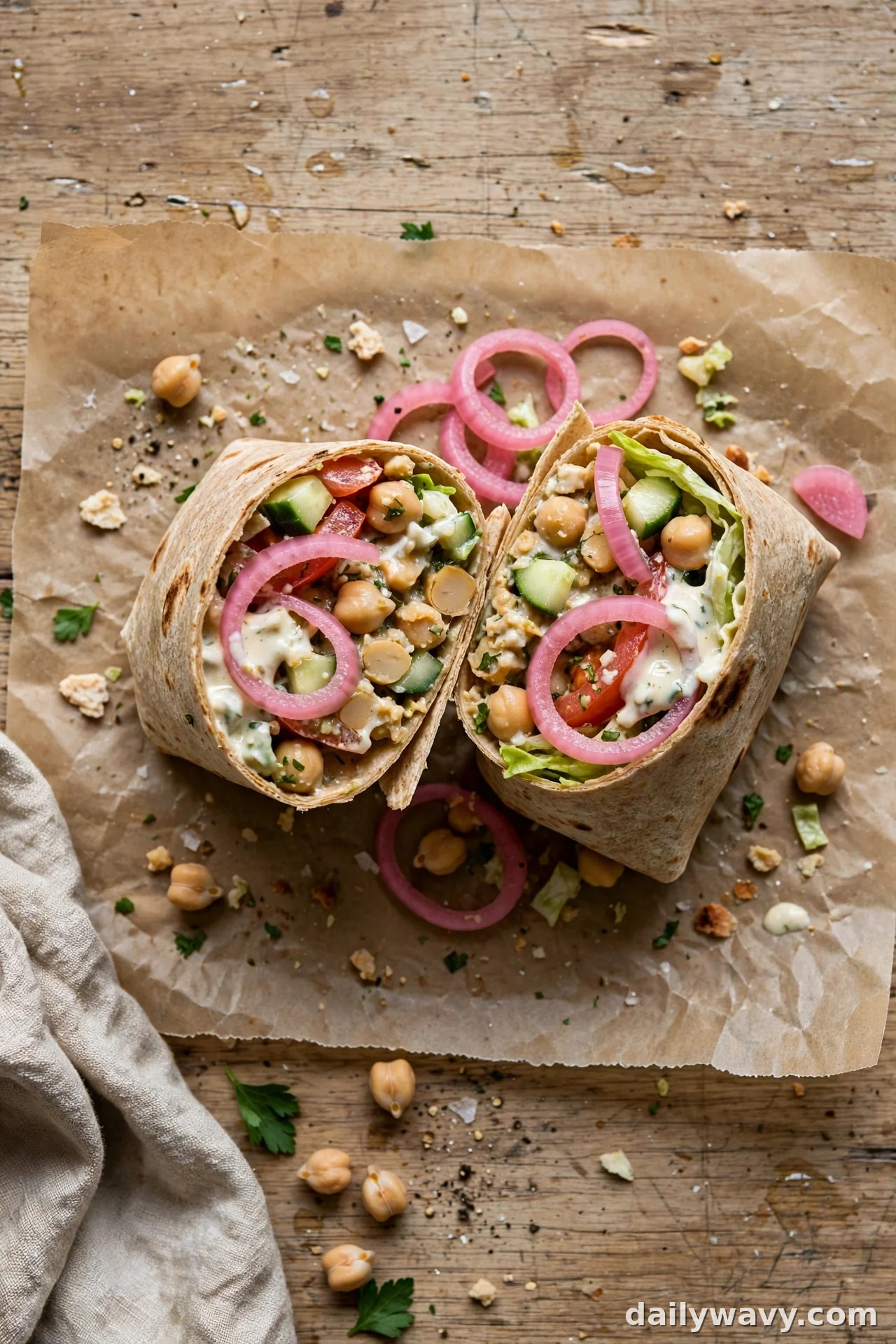 Overhead view of chickpea wrap with pickled red onion rings and garlic sauce