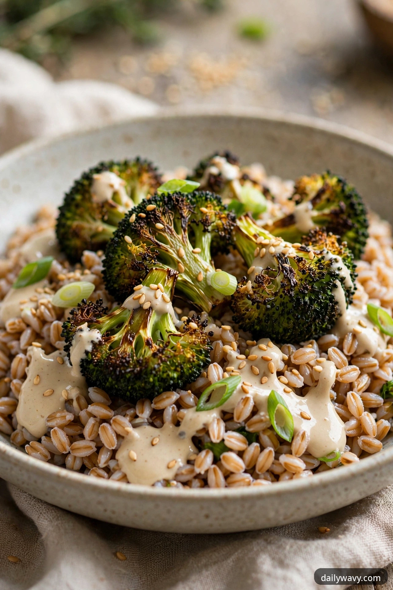 Farro salad with roasted broccoli florets, tahini dressing, sesame seeds and scallions