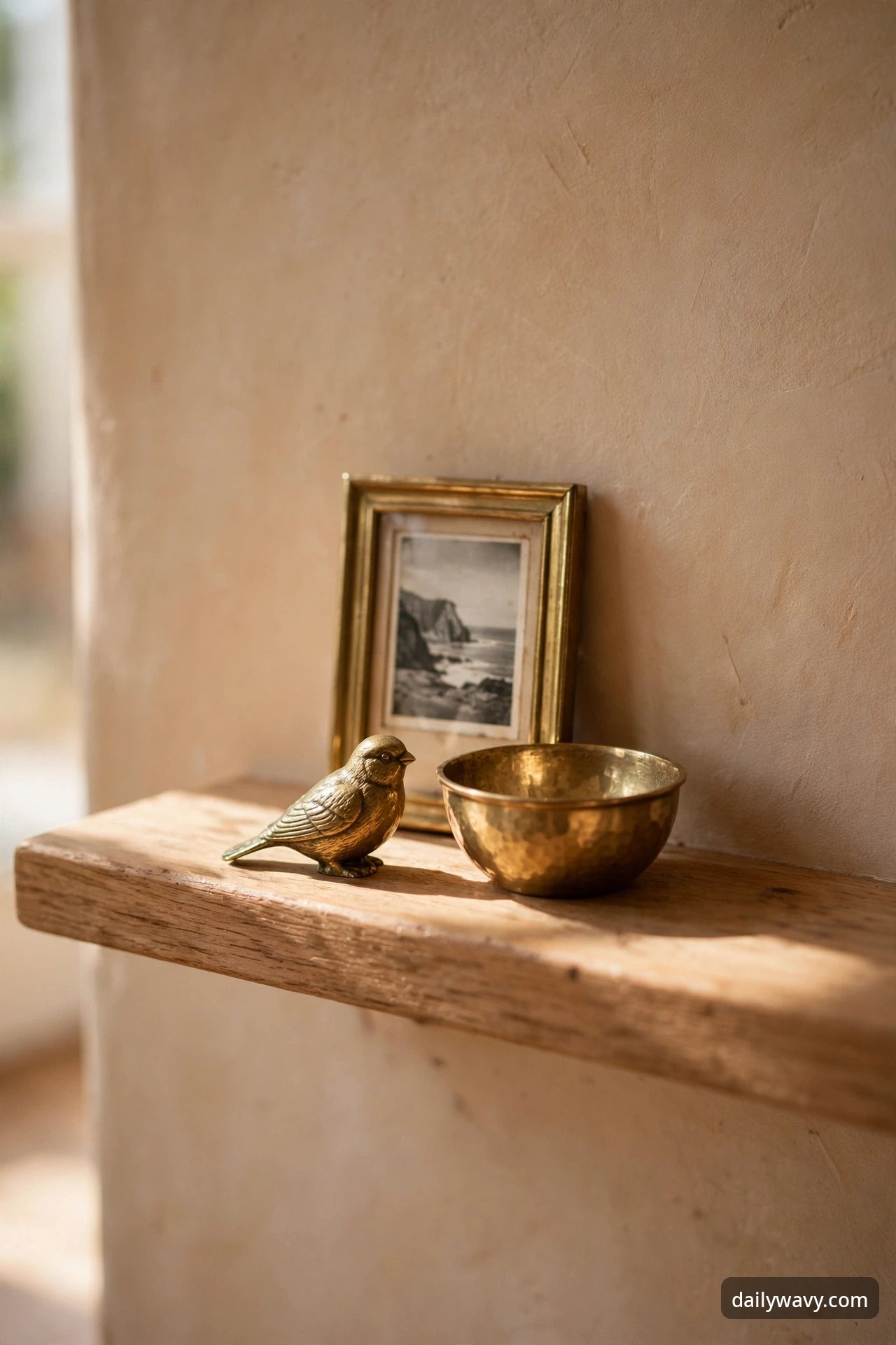Trio of small brass collectibles grouped on a floating shelf