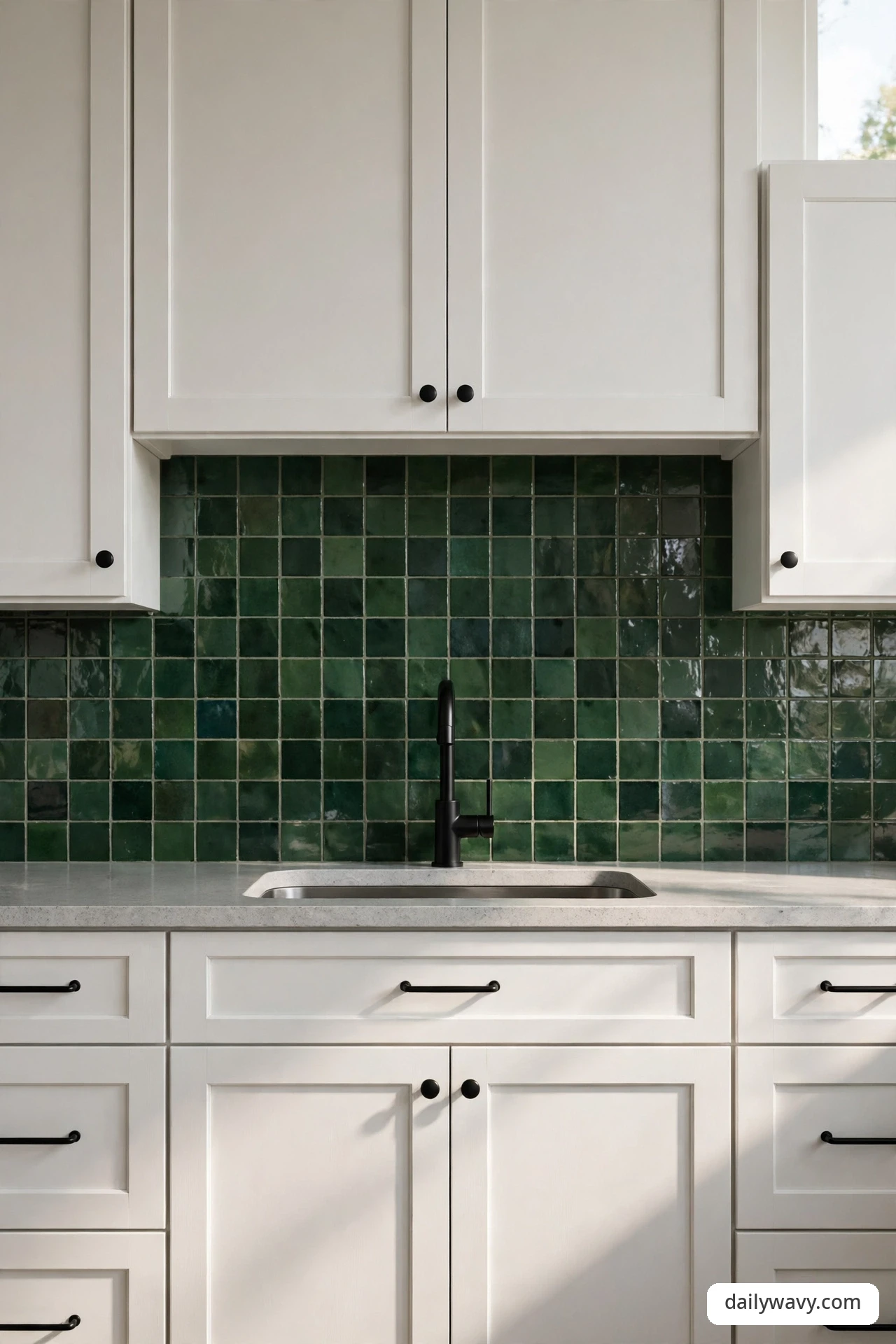 Deep green tile backsplash with matte black cabinet hardware and matching faucet