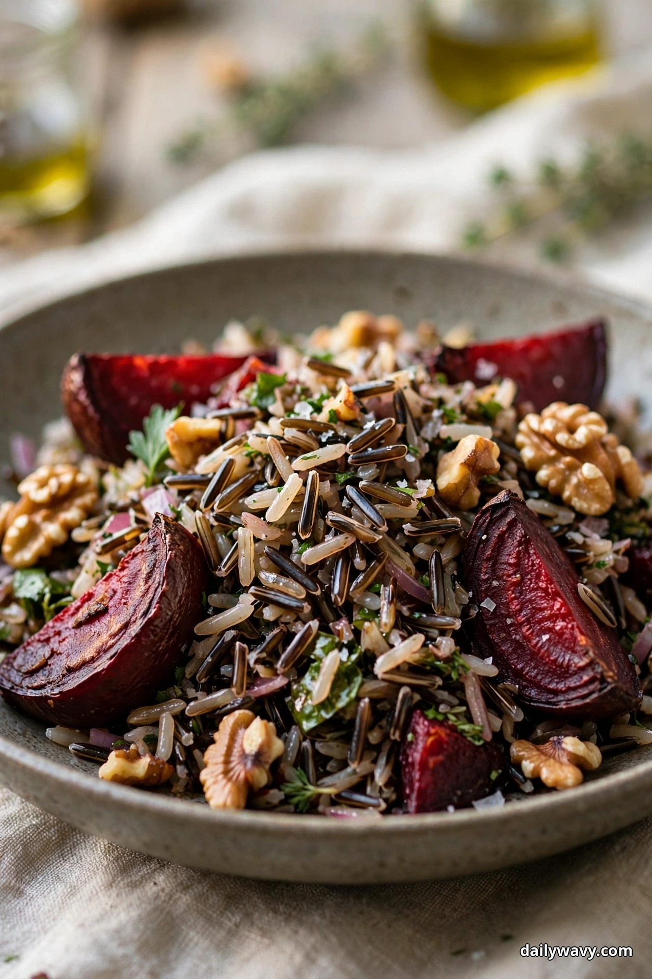 A bowl of wild rice salad is topped with roasted beet wedges and toasted walnut halves